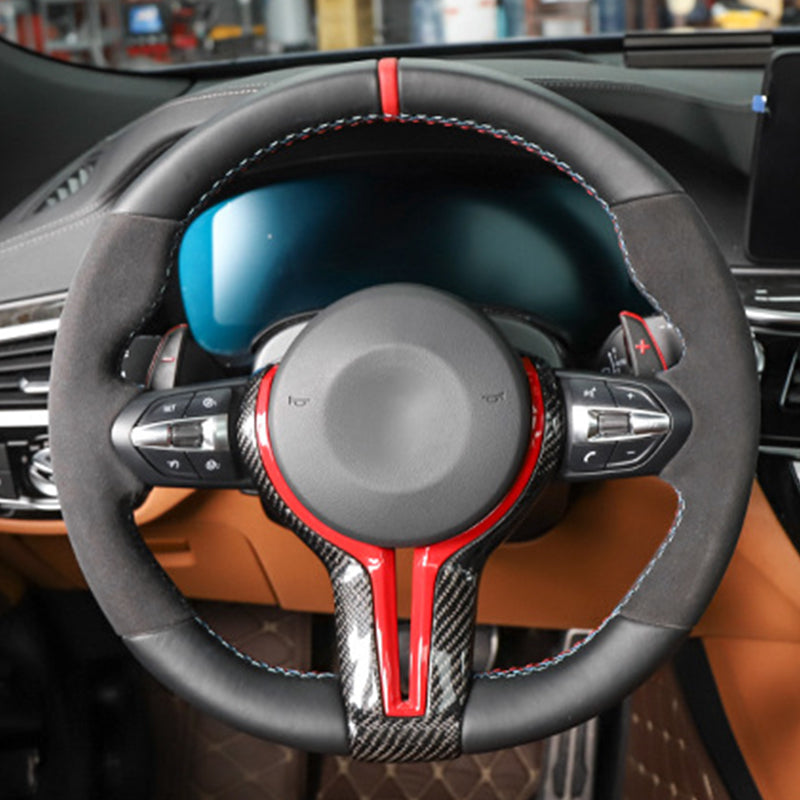 BMW carbon fiber steering wheel with black leather and red accents in luxury car interior