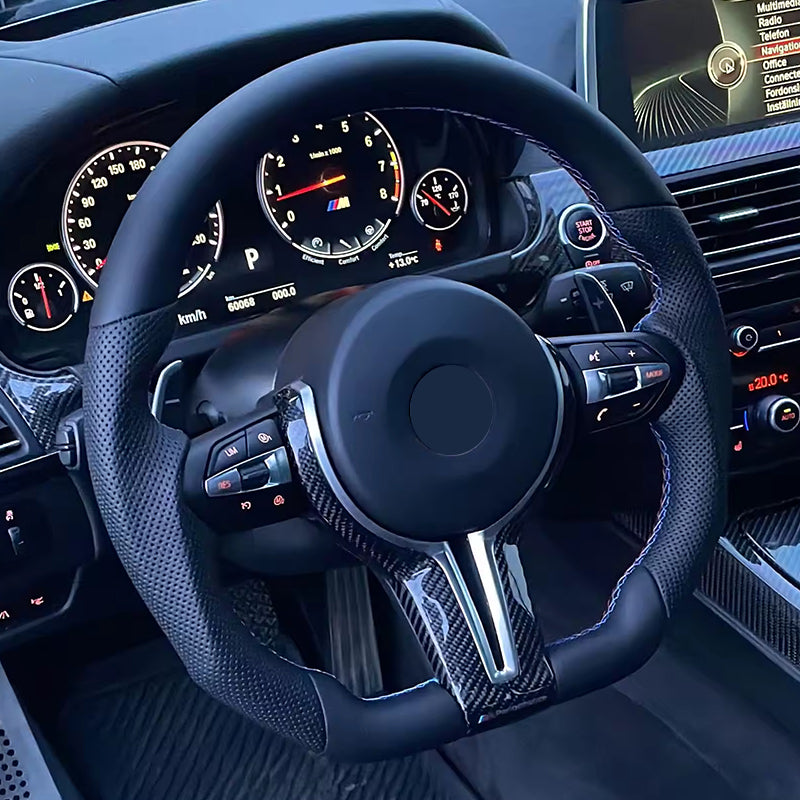 BMW carbon fiber steering wheel with perforated leather grip and multi-function controls inside luxury car