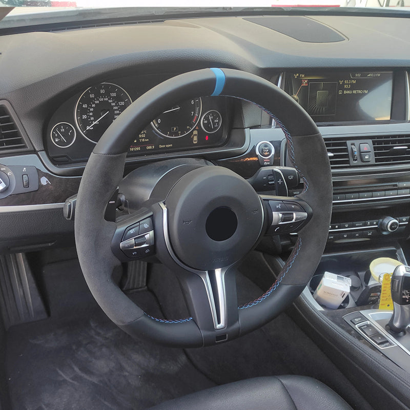 Custom BMW steering wheel upgrade with black suede and blue accent inside BMW car interior