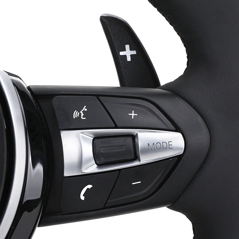Close-up of BMW forged carbon steering wheel controls with mode and volume buttons