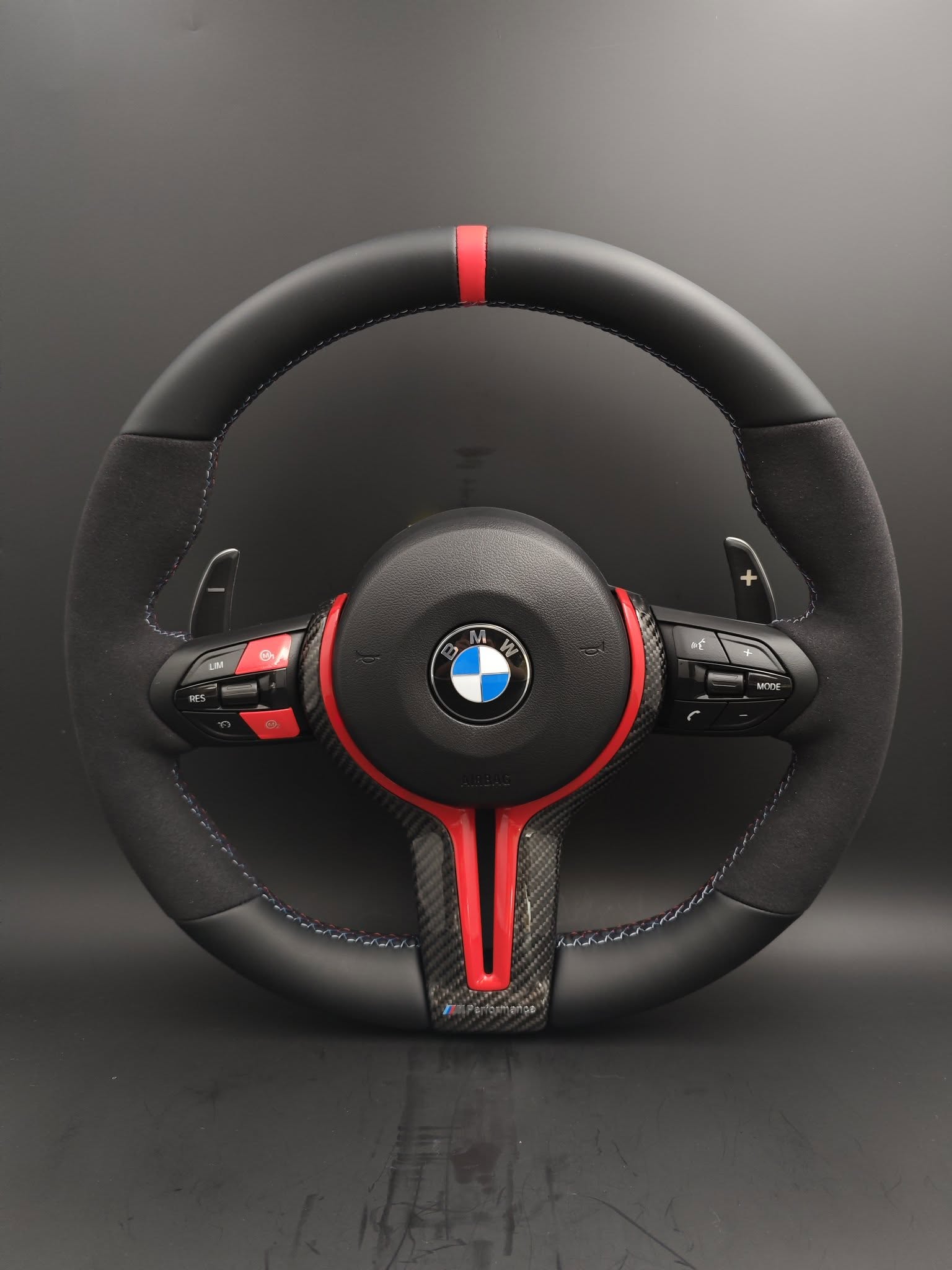 BMW performance steering wheel replacement with black and red design featuring control buttons and carbon fiber accents