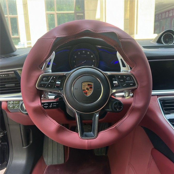 Custom Porsche steering cover in burgundy leather fitted on a Porsche steering wheel inside the car