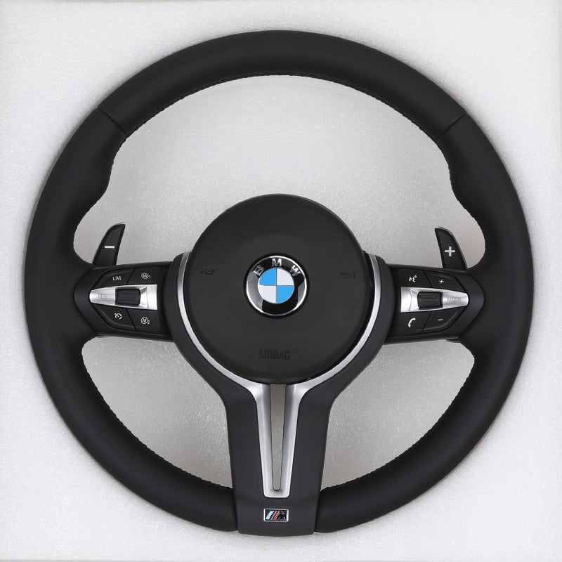 Black steering wheel with BMW logo on a white background