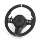 Black steering wheel with carbon fiber accents on a white background