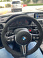 Steering wheel of a BMW car with dashboard and road view