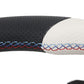 Close-up of a black and white steering wheel cover with red and blue stitching on a white background.