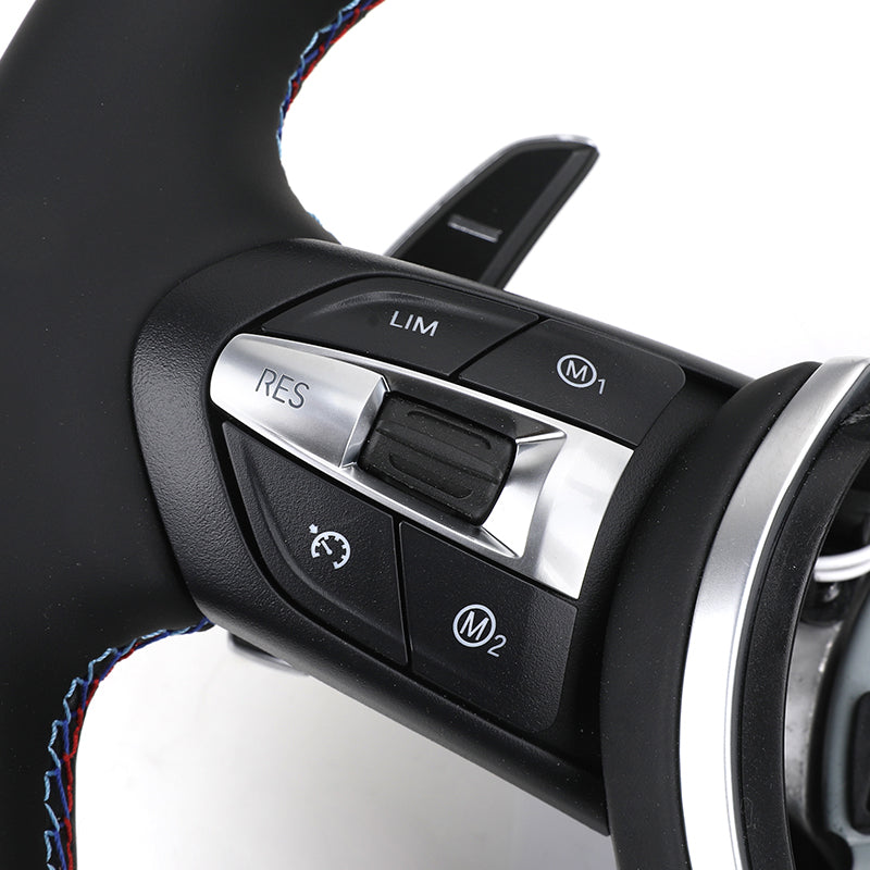 Close-up of a car steering wheel with control buttons on a white background