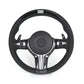 Black steering wheel with carbon fiber accents on a white background
