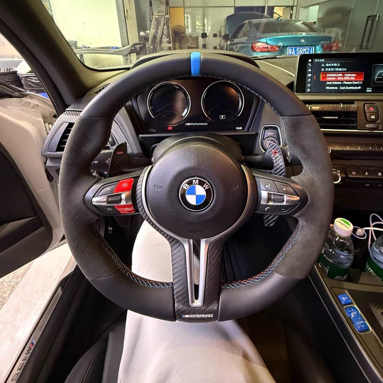 BMW performance carbon fiber steering wheel with leather grip and blue center marker inside BMW car