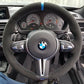 Custom BMW carbon steering wheel with suede grip and blue center stripe inside BMW sports car