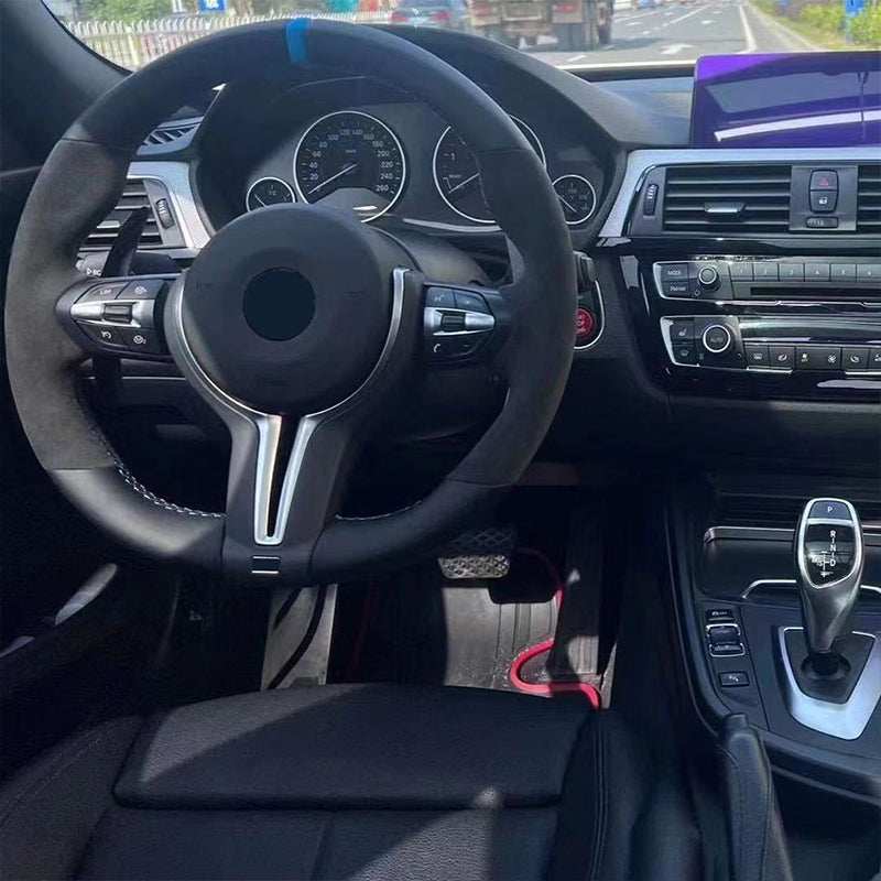 Custom BMW steering wheel upgrade installed in a BMW car interior with dashboard and gear shift visible