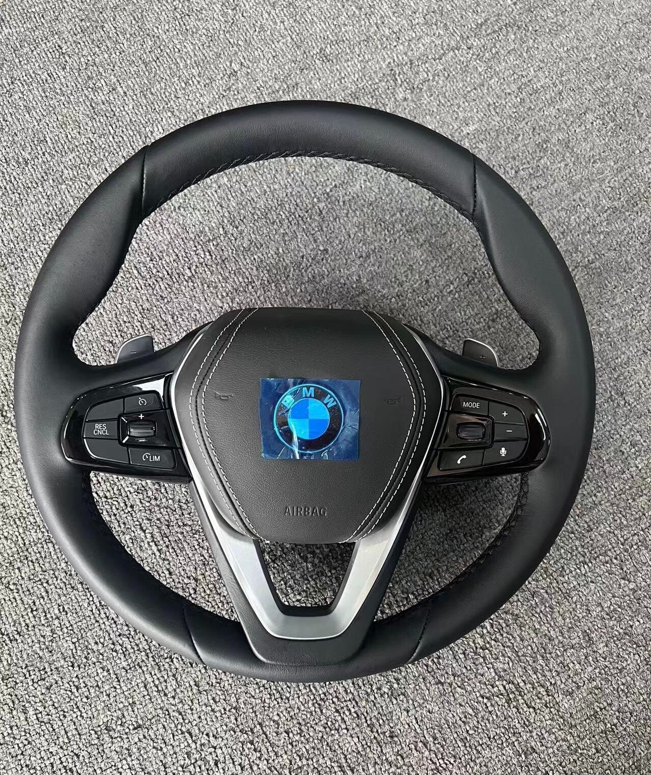 BMW steering wheel featuring forged carbon fiber BMW interior with control buttons and leather wrap