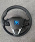 BMW steering wheel featuring forged carbon fiber BMW interior with control buttons and leather wrap