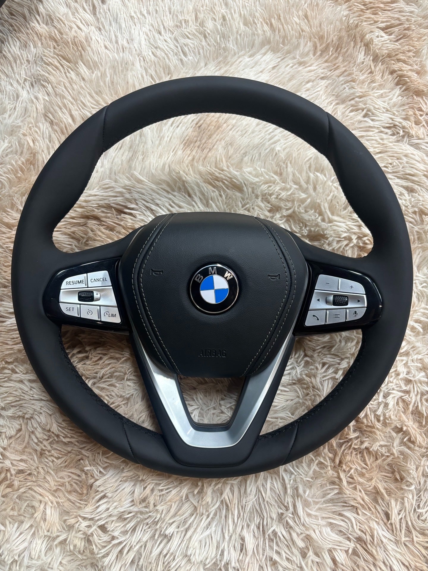 Forged carbon fiber BMW interior steering wheel with integrated control buttons and leather grip