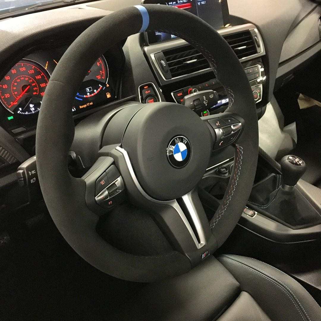 BMW forged carbon steering wheel with suede grip and blue centering stripe inside BMW car interior