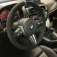 BMW forged carbon steering wheel with suede grip and blue centering stripe inside BMW car interior