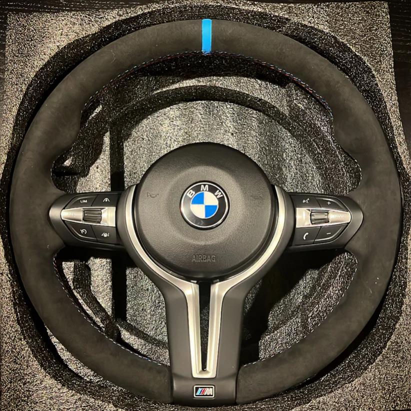 BMW forged carbon steering wheel with suede grip and blue center stripe for high performance control