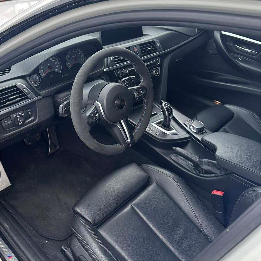 BMW forged carbon steering wheel inside luxury BMW car interior with black leather seats