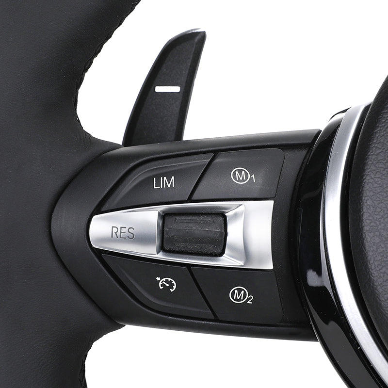 Close-up of BMW forged carbon steering wheel control buttons with cruise and memory functions