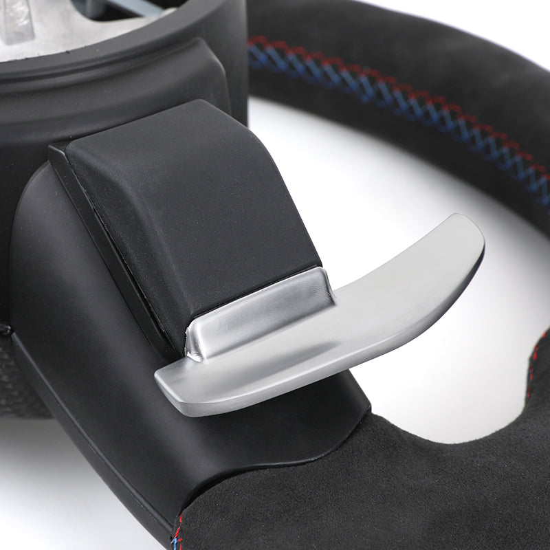 Close-up of BMW steering wheel paddle shifter with black and red stitching as BMW interior performance accessories
