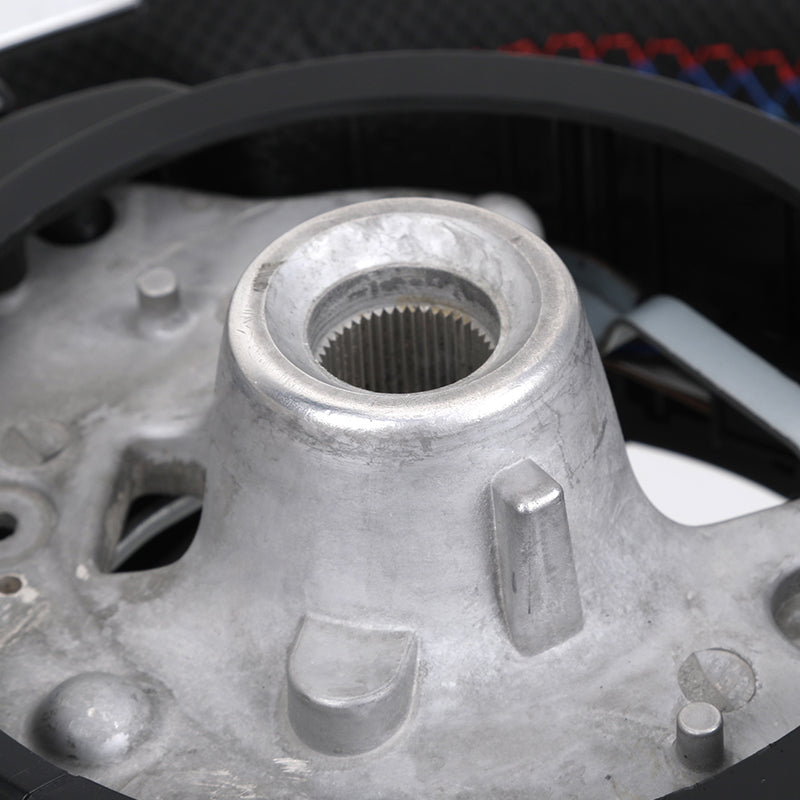 Close-up of BMW M series carbon steering wheel central hub showing metal mounting and internal spline