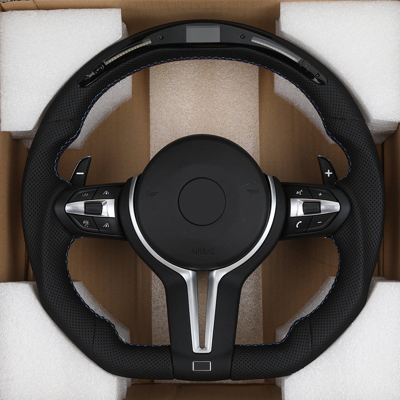 BMW M series carbon steering wheel with perforated leather and integrated control buttons in protective packaging