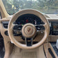 Custom Porsche steering cover fitted on beige Porsche steering wheel inside luxury car interior