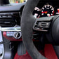 Close-up of Porsche leather steering wheel cover inside luxury car interior with dashboard controls