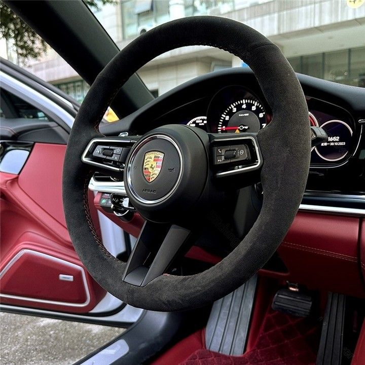 Porsche leather steering wheel cover on black steering wheel inside luxury Porsche car interior