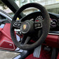 Porsche leather steering wheel cover on black steering wheel inside luxury Porsche car interior